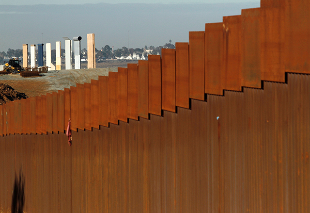 photo of fence at border with wall prototypes in background