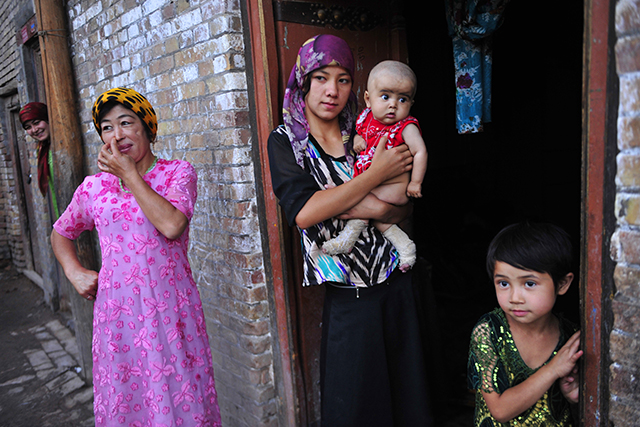An ethnic Uyghur woman hugs her son