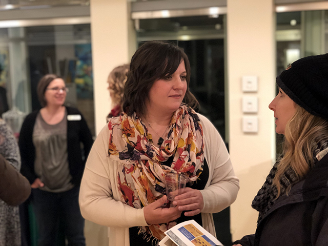 Little Falls artist Heidi Jeub visiting with a guest at an exhibition of her work in St. Cloud.
