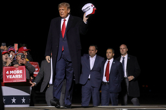 President Donald Trump holding MAGA hats