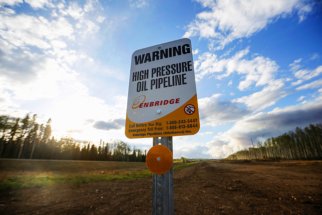 An Enbridge high pressure oil pipeline sign standing near Kinosis, Alberta, Canada.