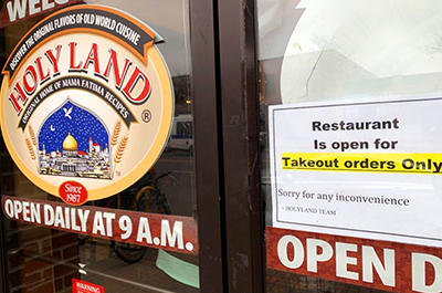 A "take-out only" sign on the front door of Holy Land
