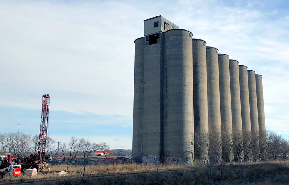 Though the drilling rig stood a good 25’ high, it was still dwarfed by the massive abandoned grain silos that have long stood sentry over this overlooked part of town.