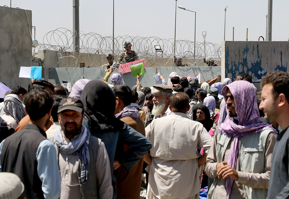 Crowds of people show their documents to U.S. troops outside the airport in Kabul, Afghanistan, on Thursday.