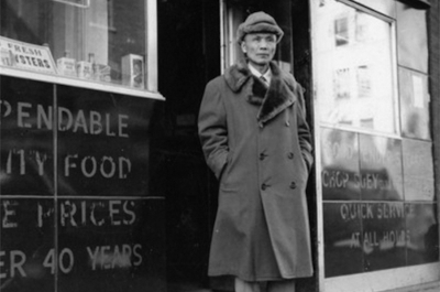 image of man in coat standing outside restaurant