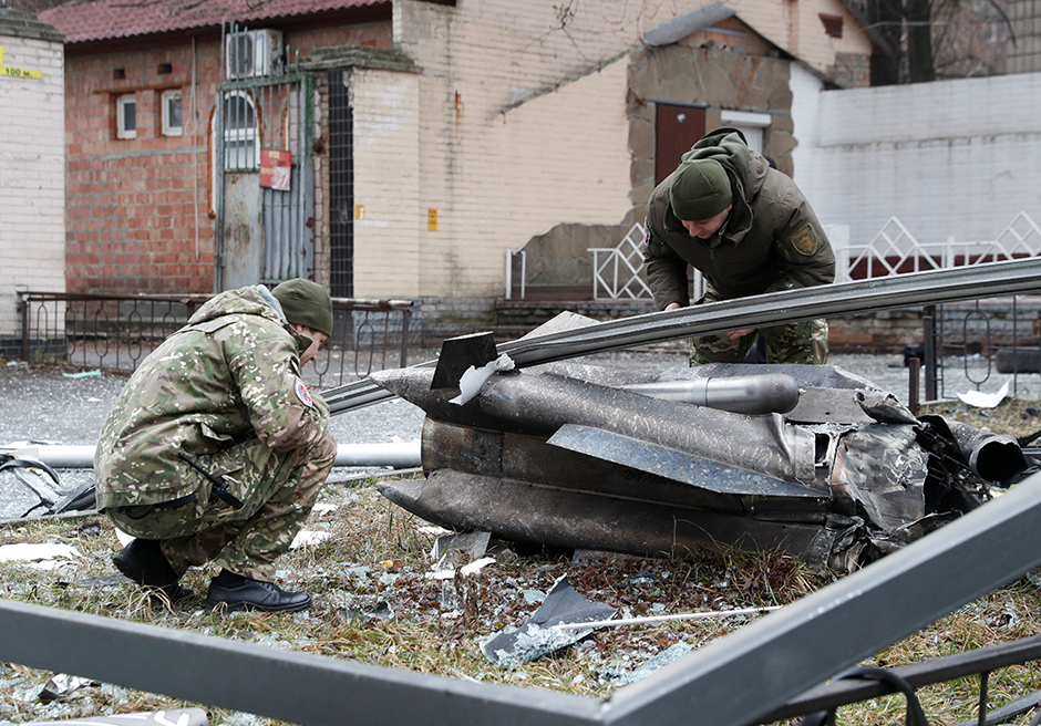 Police officers inspect the remains of a missile that fell in a Kyiv street on Thursday.