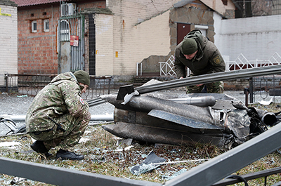 Police officers inspect the remains of a missile