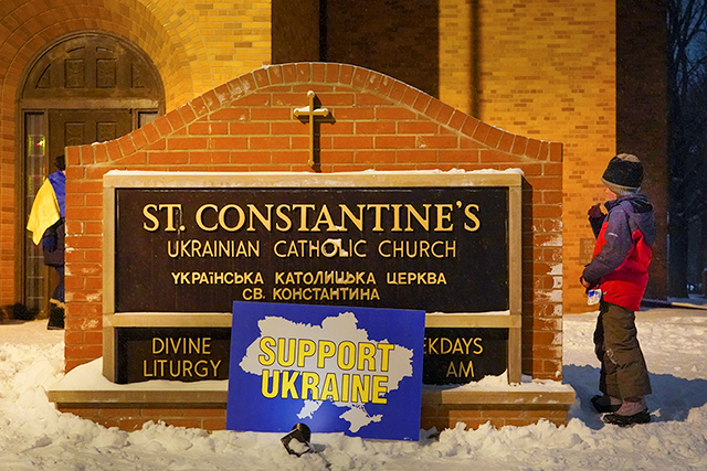 A placard reading “Support Ukraine” resting against the sign at St. Constantine Ukrainian Catholic Church during the February 24 rally and service.