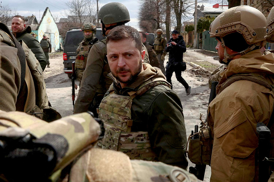 Ukraine's President Volodymyr Zelensky surrounded by Ukrainian servicemen in Bucha, outside Kyiv, on Monday.