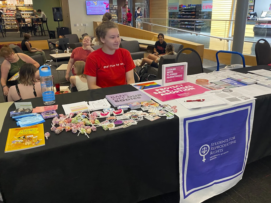Anna Bottesini sits in the University of South Dakota student center ready to answer questions about abortion access and share resources with her fellow students.