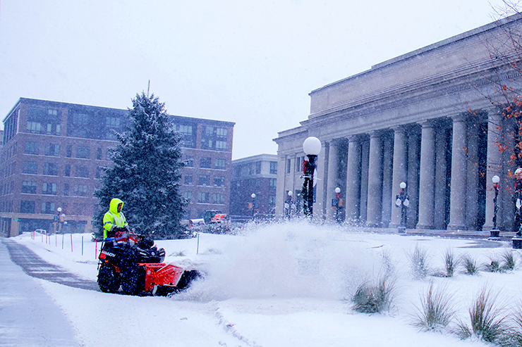 A snow plower clearing the sidewalks in front of Union Depot.