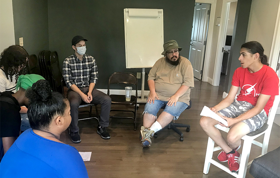 Pod leaders Gus Rodriguez, left, and Will Navarro, right, meet with their students in the “living room” of the McKenna Center. Students are encouraged to set goals and advocate for changes that will help them attain them.