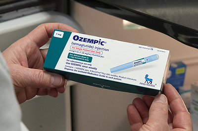 A pharmacist displaying a box of Ozempic, a semaglutide injection drug used for treating type 2 diabetes and made by Novo Nordisk.