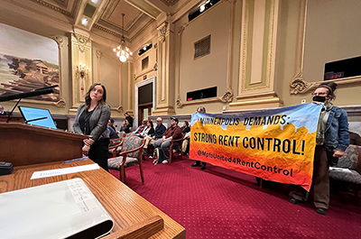 Rent control supporters holding a banner as staff with the city of Minneapolis urged the city council not to adopt a rent control policy during a committee meeting on Tuesday.