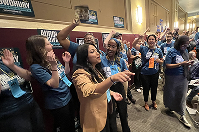 Aurin Chowdhury, left, in brown blazer, cheers with supporters after delegates at the Minneapolis DFL's Ward 12 convention voted to endorse Chowdhury in her race for an open city council seat on Saturday, April 30.