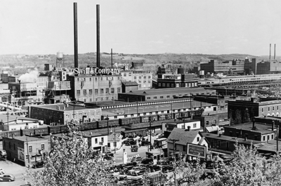 In 1919, the Swift company arrived, a massive Chicago-based company that slowly grew its slaughterhouse operation next to the stockyards. Armour is in the far right background.