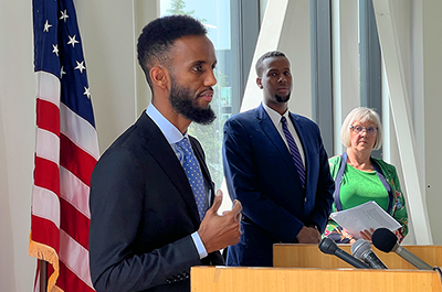 Minneapolis City Council candidate Nasri Warsame, left, speaking during a press conference, as campaign manager Abshir Omar, center, and a supporter look on.