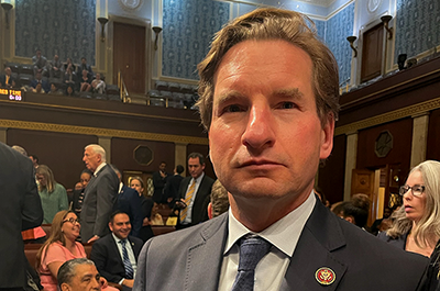 Before the procedural vote, Rep. Dean Phillips was photographed standing proudly on the House floor with both a red card (for no) and a green card (for yes) in his jacket pocket.