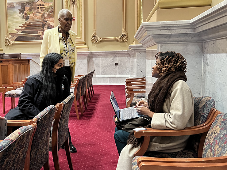 Minneapolis City Council president Andrea Jenkins, standing, and council member Aisha Chughtai speaking with a resident after a meeting on March 23, 2023.