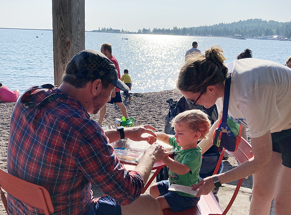 Stu and Ann Harty, with baby Sam, of Minneapolis, creating postcards on the Letteracy Deck.