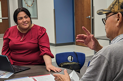 Community health worker Laura San Miguel talks with a longtime HealthFinders patient about diabetes management.