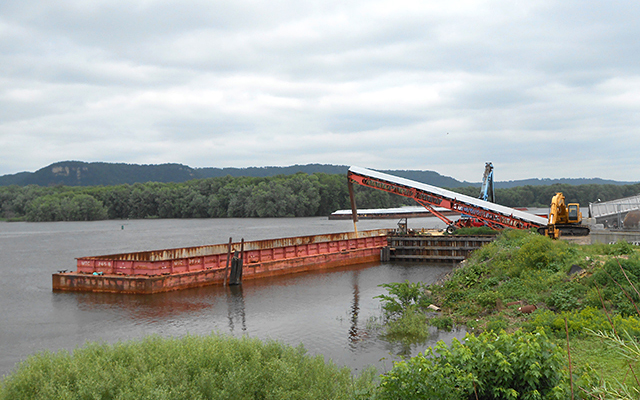 Frac sand being loaded onto a barge on the Mississippi River in Winona.