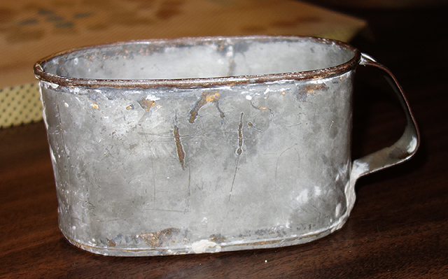 A metal cup once used by inmates in the jail