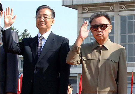 China's Premier Wen Jiabao, left, waves beside North Korea's leader Kim Jong-il after his arrival in Pyongyang, Sunday, Oct. 4, 2009.