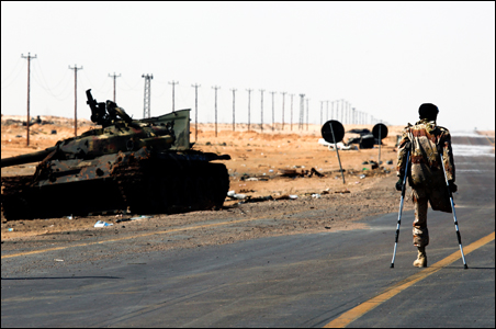 A rebel fighter with an amputated leg walks along the front line at the western entrance of Ajdabiyah.