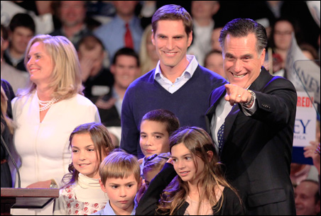 Mitt Romney points to supporters as he stands on stage with his relatives while speaking at his New Hampshire primary night rally.